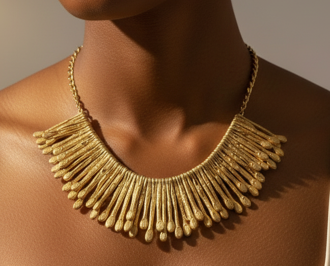 Close-up of hammered 18K gold-plated brass statement earrings with tapered fringe design, photographed on a model. ZoharasVogue