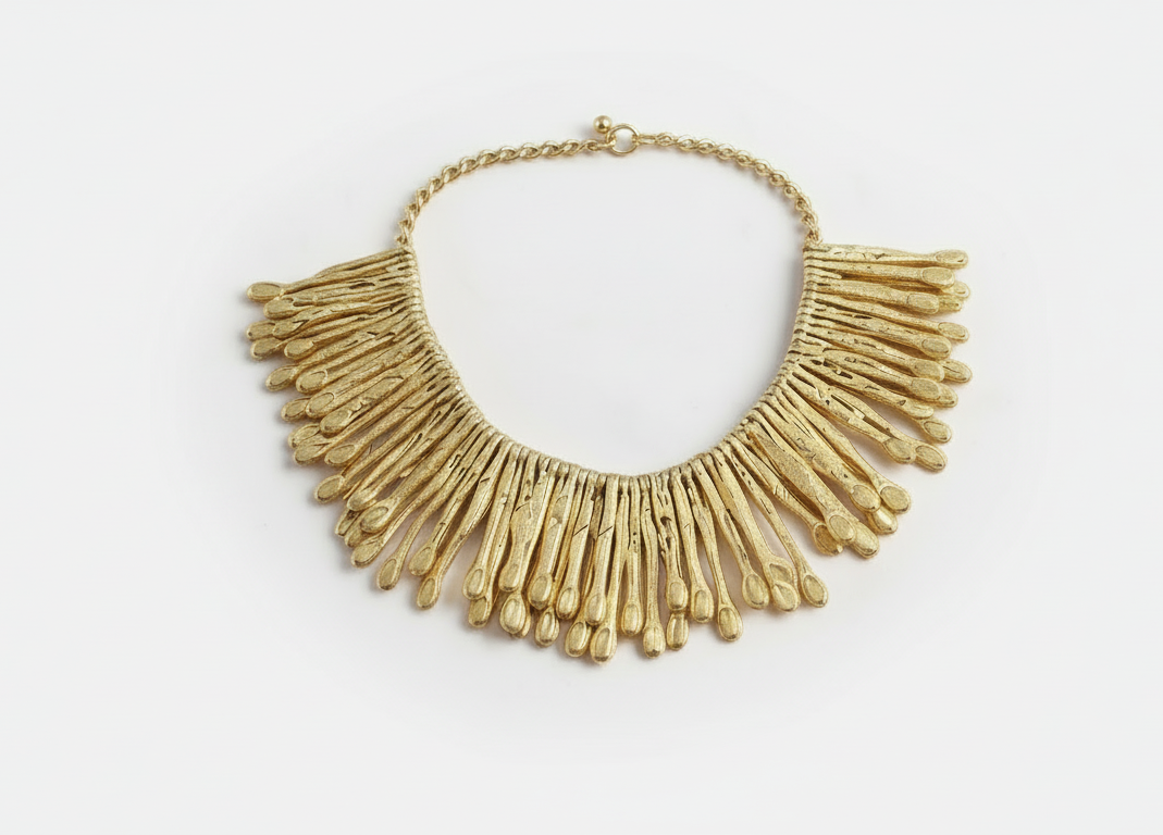 Close-up of hammered 18K gold-plated brass statement earrings with tapered fringe design, photographed on a model. ZoharasVogue