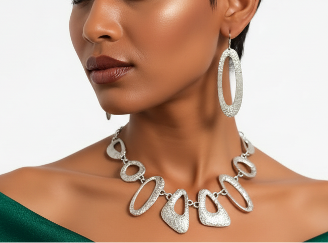 Model wearing a green off-shoulder top and silver jewelry on a white background