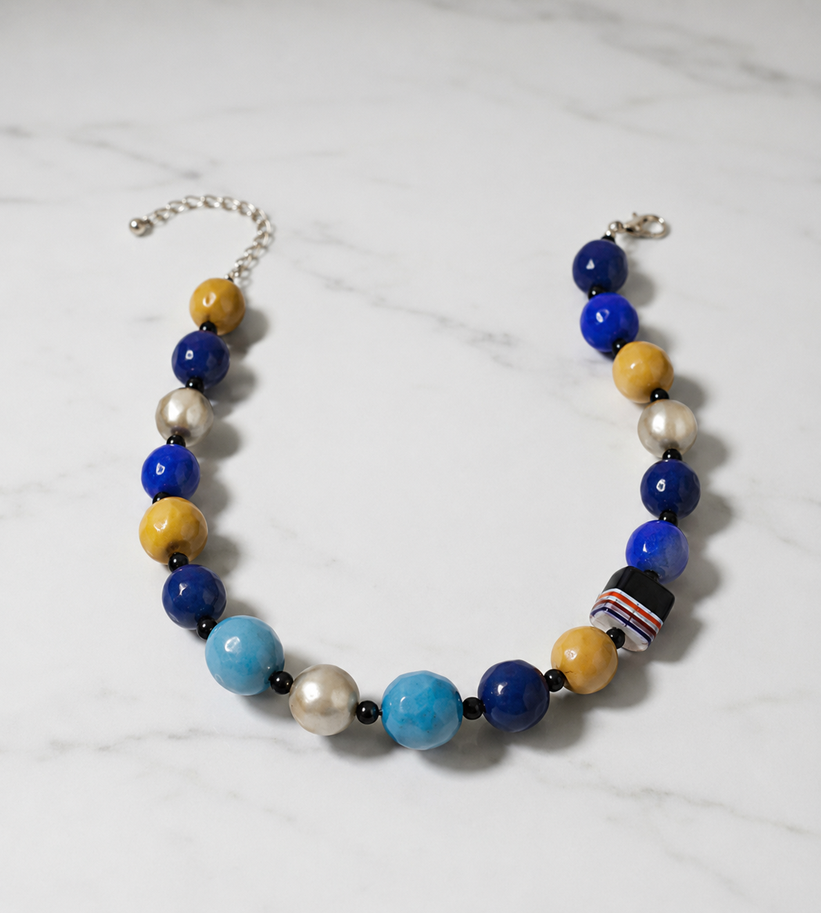 Cobalt Mosaic Statement Necklace, cobalt blue, mustard yellow, turquoise and pearl-tone beaded statement necklace with black spacers, striped accent bead and silver-tone adjustable clasp. ZoharasVogue 