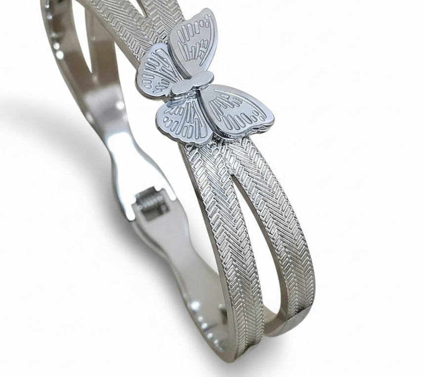 Silver bracelet with butterfly charm on a white background. ZoharasVogue