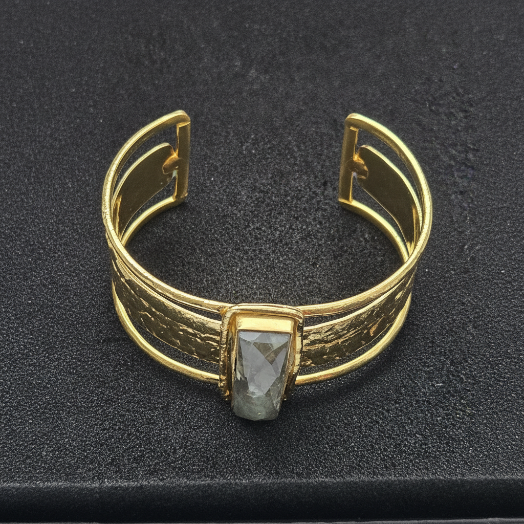 Gold bracelet with a central gemstone on a black background_ZoharasVogue