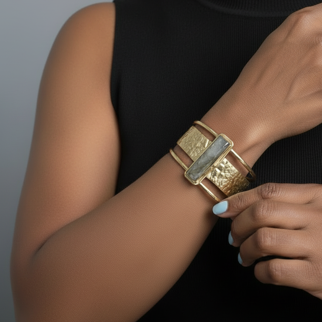 Person wearing a gold bracelet on a plain background_ZoharasVogue