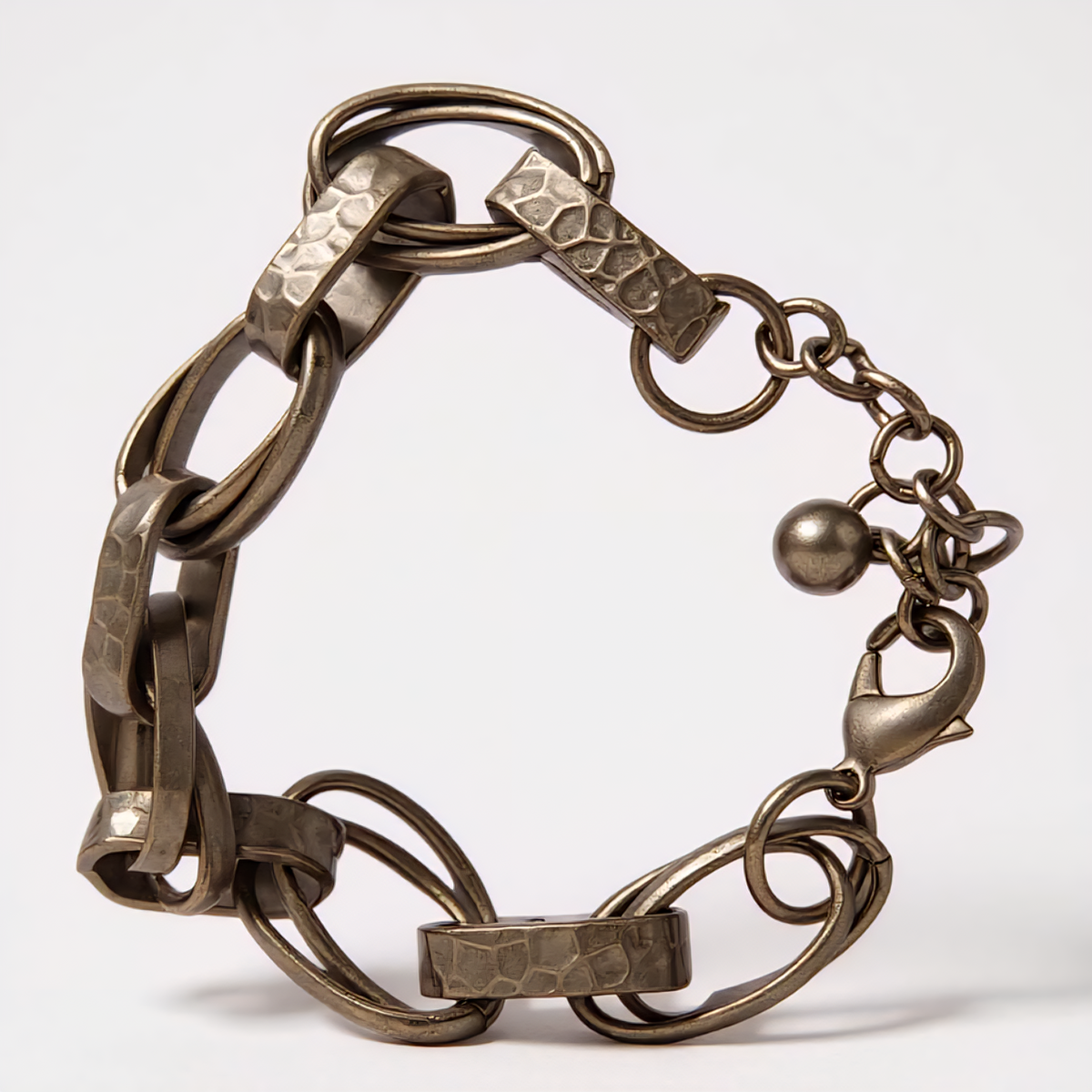 Obsidian Smoke Bracelet with hammered oval chain links in a smoky gunmetal-tone finish, accented by a single crystal detail at the clasp, styled for modern elegance. ZoharasVogue 