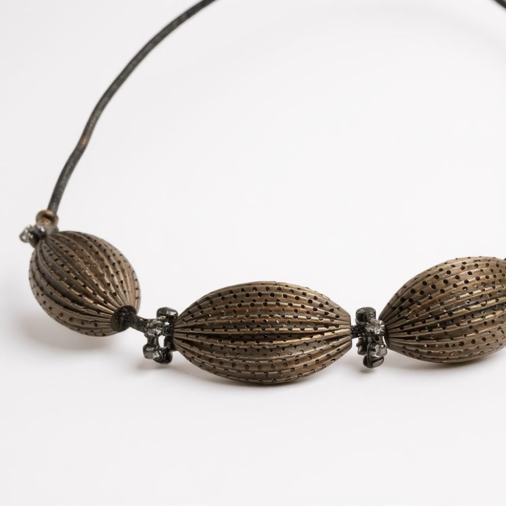 Close-up of the Obsidian Smoke Necklace featuring oversized ribbed oval beads in a gunmetal-tone finish with crystal spacer accents, arranged in a bold, sculptural design. ZoharasVogue 