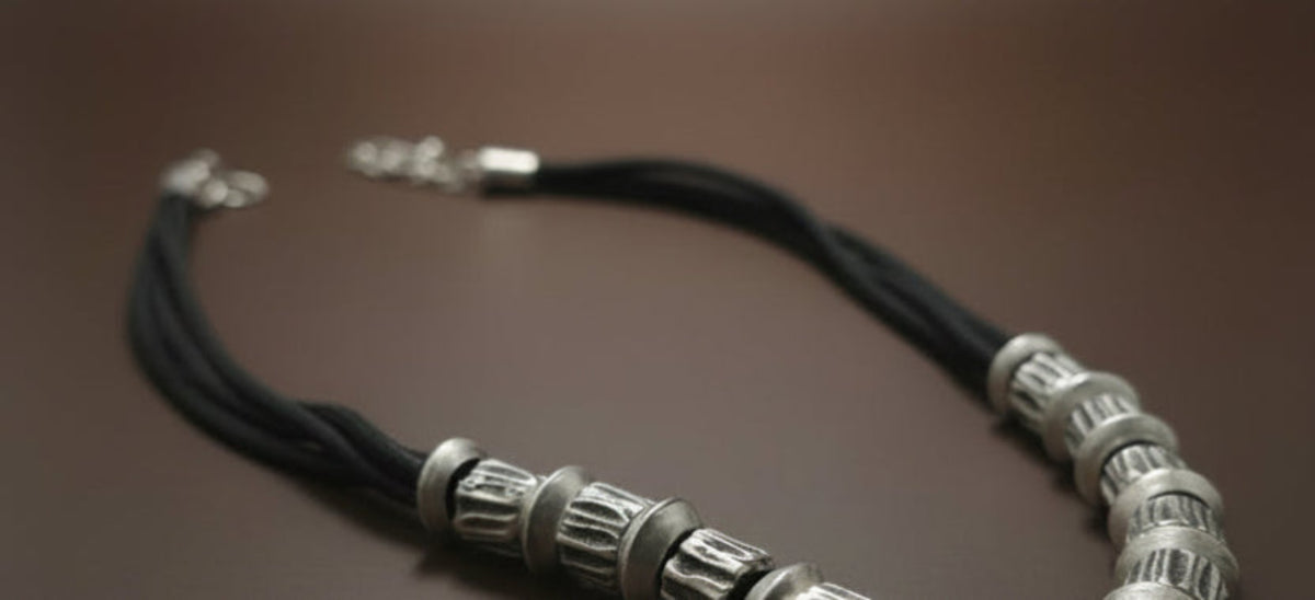 Close-up of Silver Boho Echo Necklace  with decorative elements on a neutral background