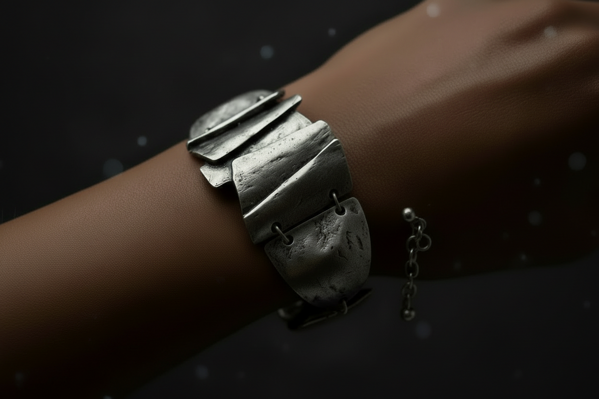 Silver bracelet on the models wrist against a dark background