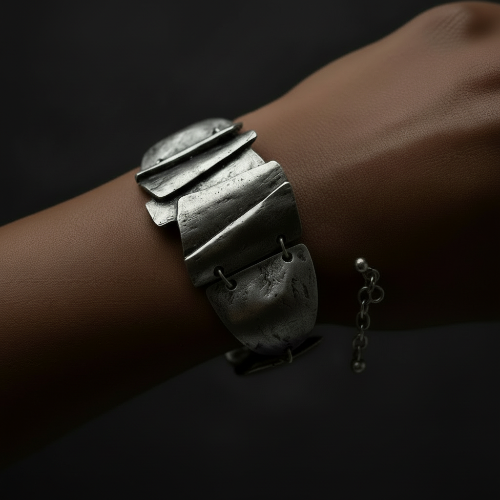 Silver bracelet on a wrist with a dark background