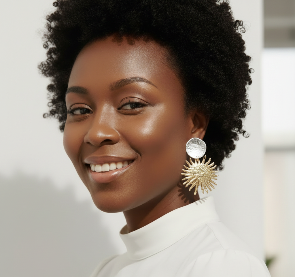 Model wearing gold earrings with a blurred background