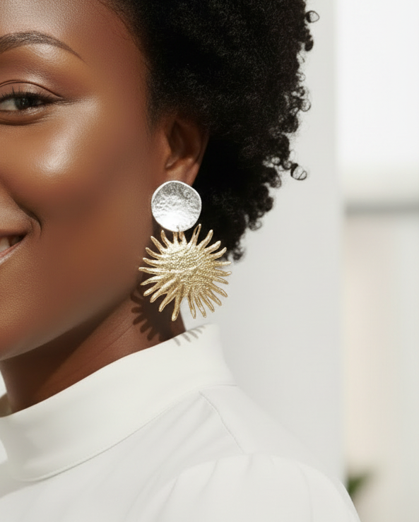 Model wearing gold earrings with a blurred background