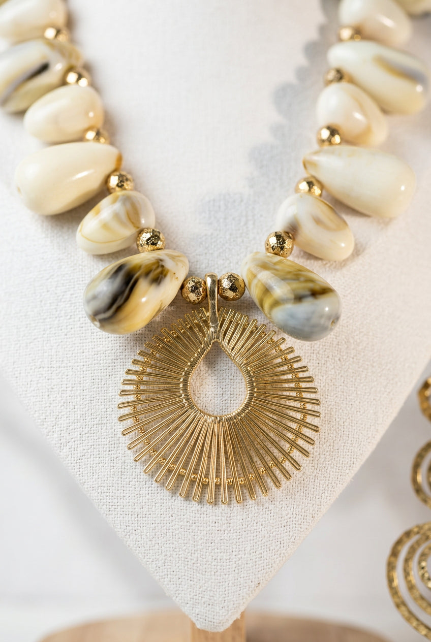 Close-up of Solaya necklace showing glossy marbled acrylic shell beads and the radiant 18K statement pendant