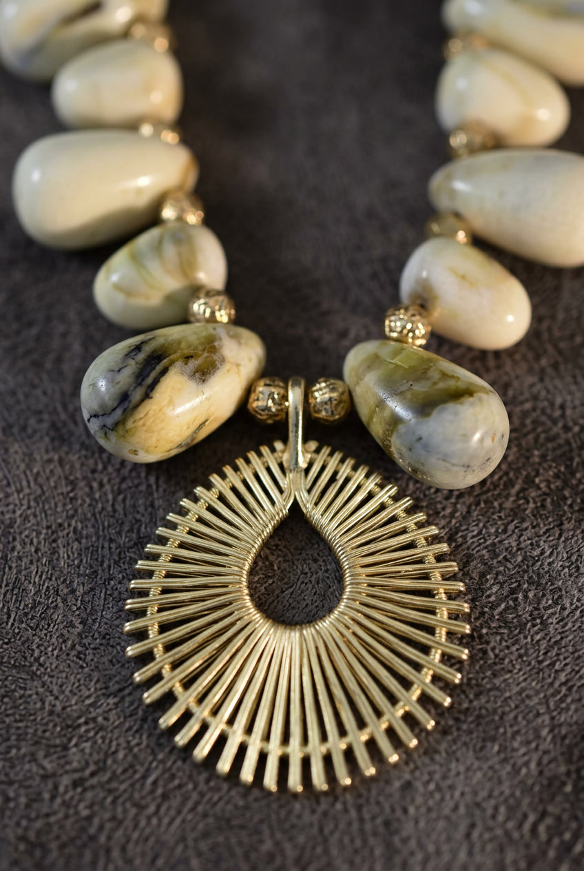 Solaya Sunburst Shell Necklace displayed with coordinating bracelet and gold earrings in a styled jewelry vignette