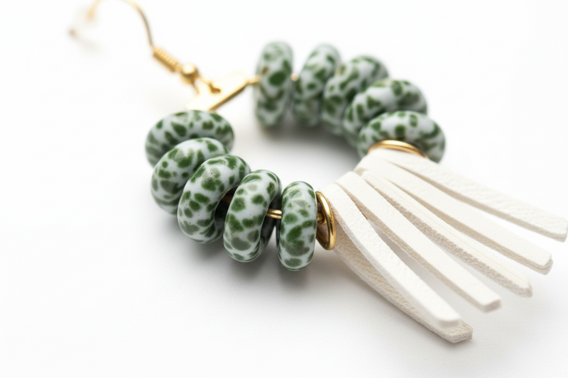 Model wearing Earrings with green bead and white tassel design on a white background Zoharas Vogue