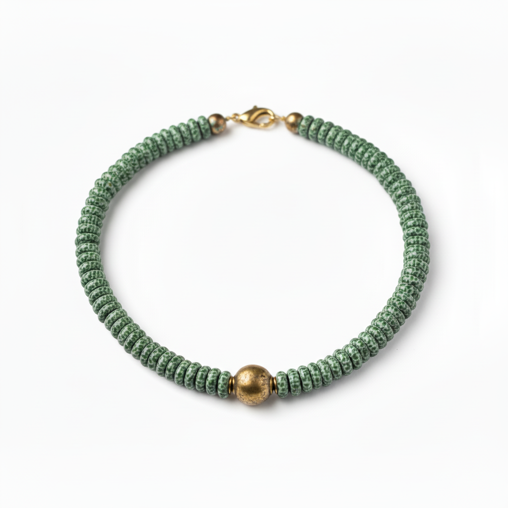 Handcrafted emerald green speckled glass bead necklace with antique brass toggle closure and matching earrings featuring white spike beads and brass spacers.