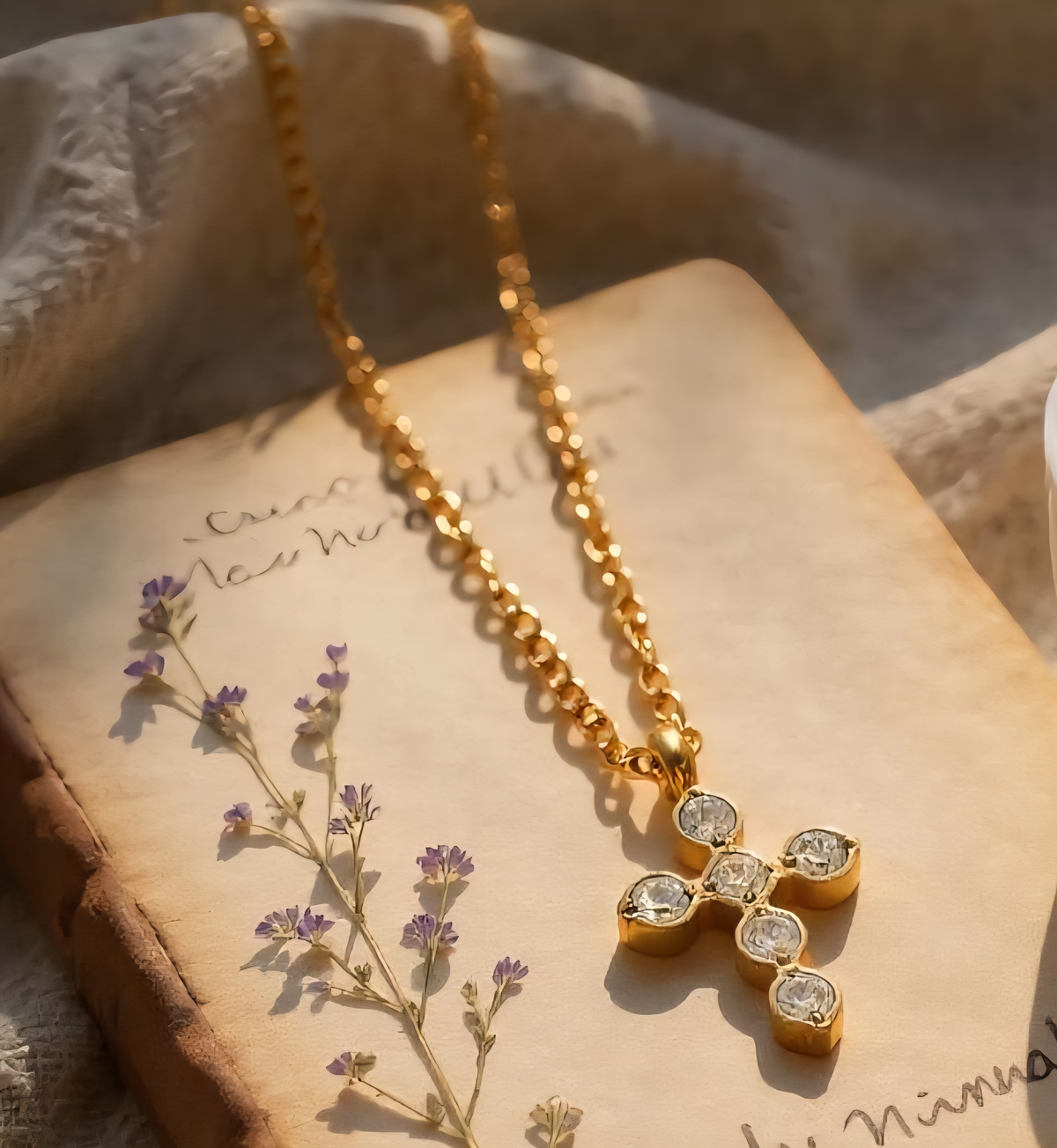 Gold necklace with a diamond pendant on an old book with flowers