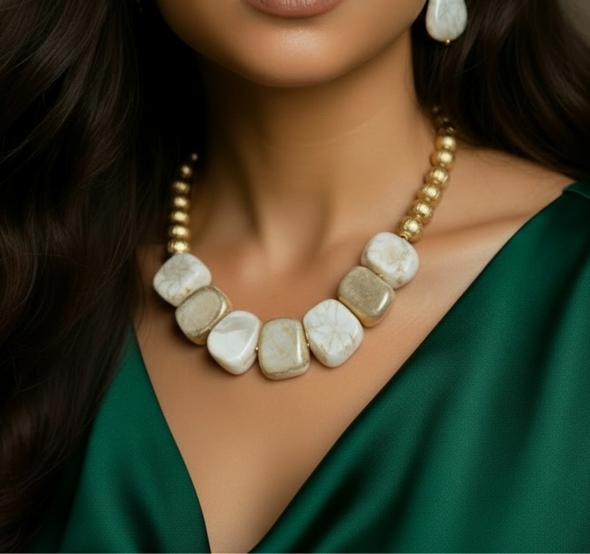 A chunky collar-style necklace featuring alternating matte gold nuggets and smooth, irregular marbled cream stones, resting on a white tufted surface. ZoharasVogue
