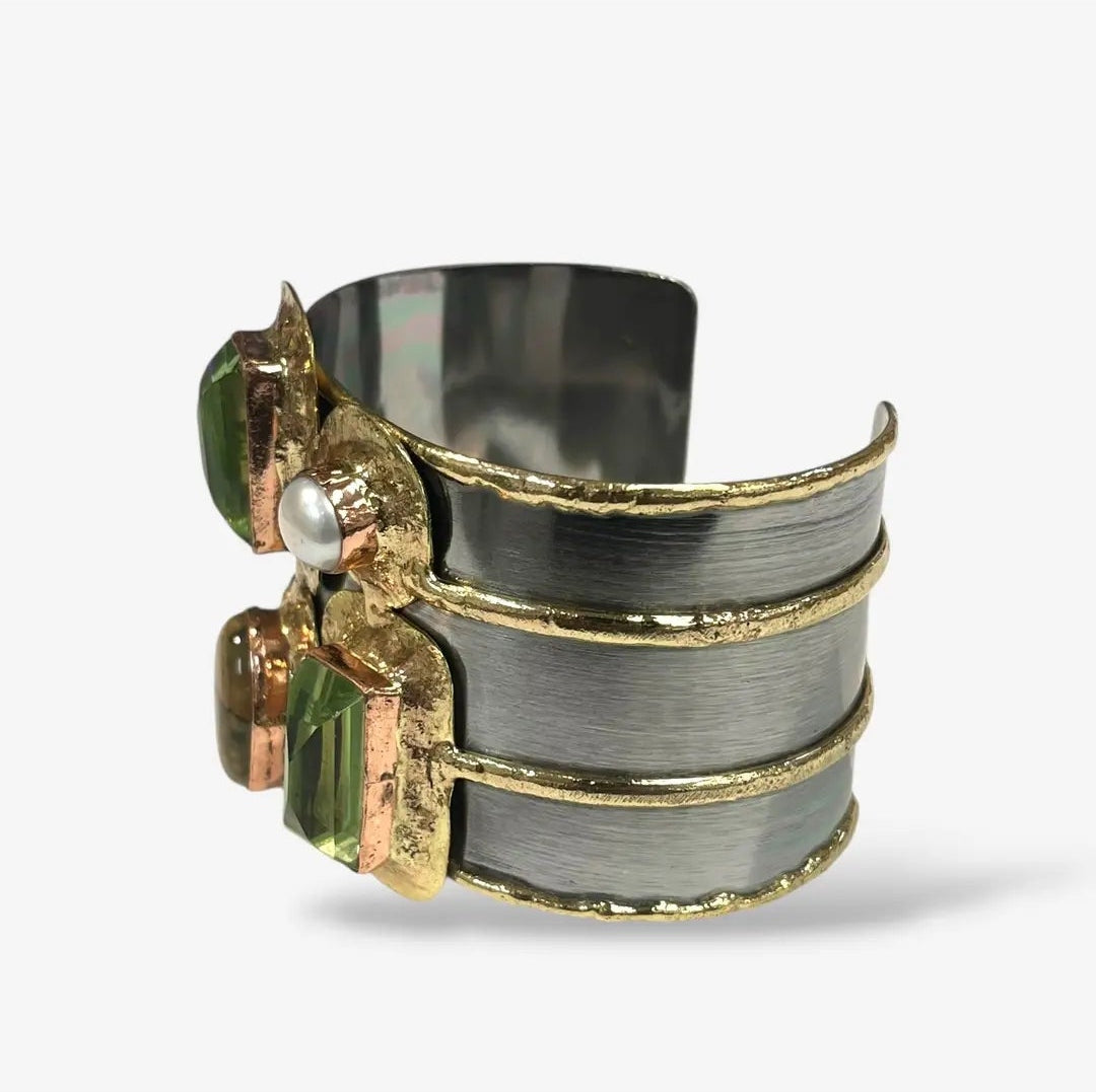 Handcrafted wide cuff bracelet with dark rectangular gemstones, pearl accents, and bold gold-tone detailing.