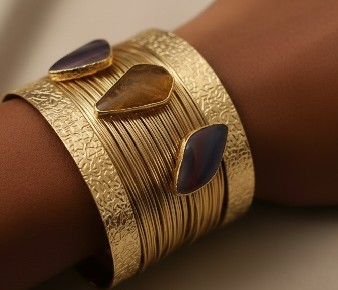 Gold bracelet with blue stones on a wrist against a neutral background ZoharasVogue 