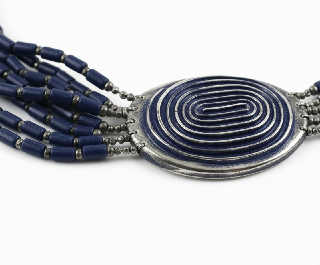 Necklace with blue beads and a silver spiral pendant on a white background_ ZoharasVogue 