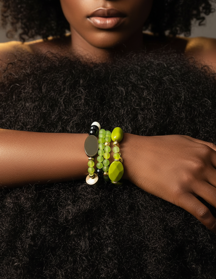 Person wearing a bracelet with green beads on a dark background_ZoharasVogue