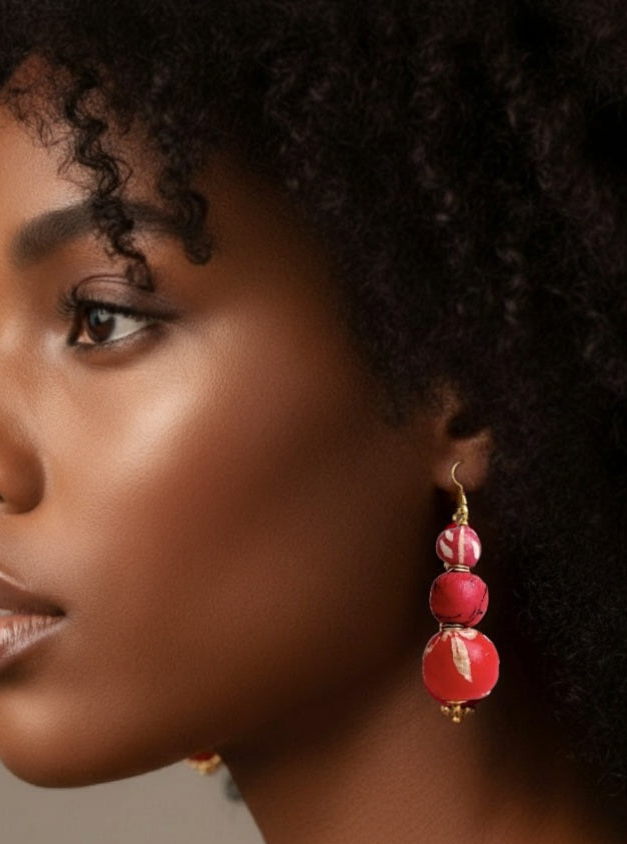 Close-up of handcrafted pink beaded earrings made from recycled sari fabric and wood, hanging against a neutral background_ZoharasVogue 