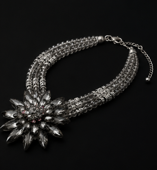 Angled view of the Valentina Noir Bloom necklace highlighting the dimensional floral crystal centerpiece and layered beaded strands.