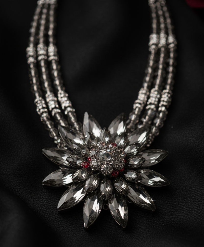 Close-up of the floral crystal pendant featuring smoky gray marquise-cut stones and intricate statement detailing. Zoharas Vogue