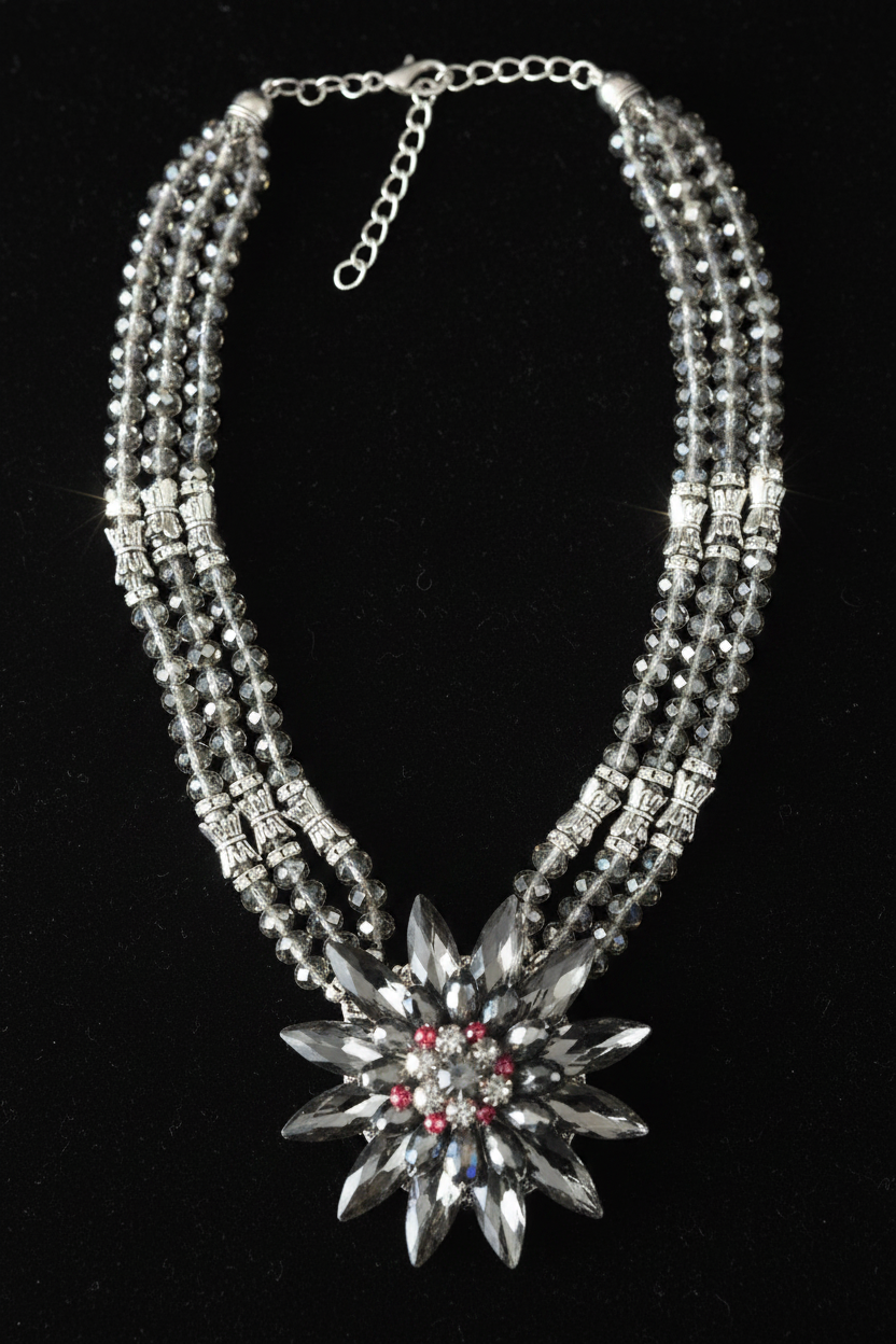 Valentina Noir Bloom statement necklace featuring a dramatic floral crystal pendant with multi-strand smoky gray beaded chains and silver accents.