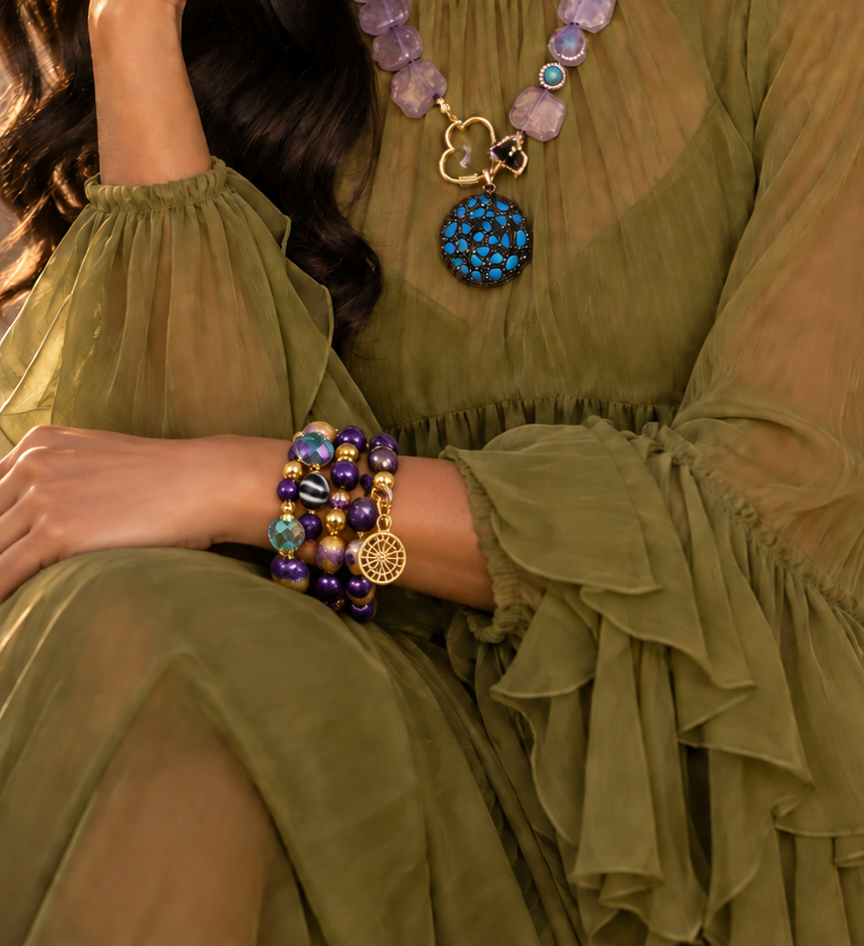 Zafira Radiant layered bracelet by ZoharasVogue featuring purple Sugilite Agate, purple-yellow Fire Agate, iridescent crystal beads, gold accents, and a sunburst charm.