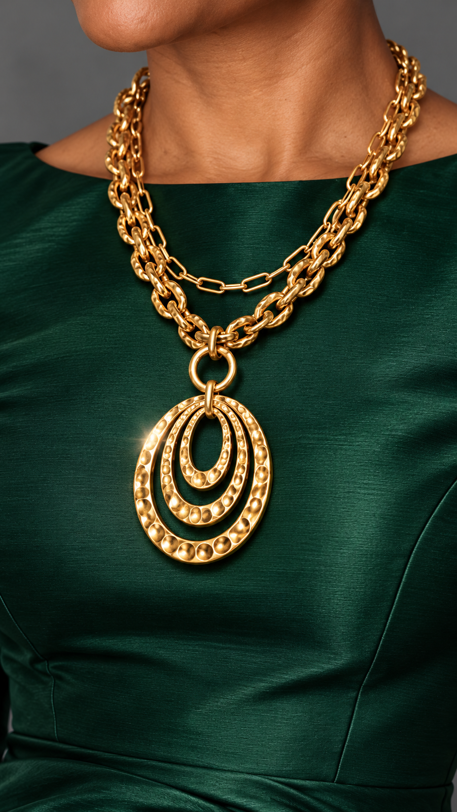 Double chain 18k gold plated necklace with three Gold nested textured oval pendants, worn over a hunter green silk dress.