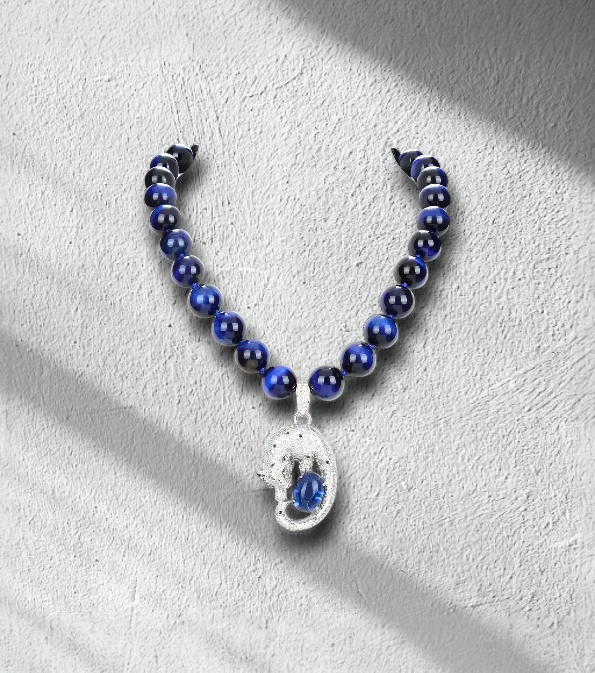 Semi-precious blue pearl necklace with Tiger Eye pendant, gold-plated clasp, bold statement jewelry for confident women. Zoharas Vogue