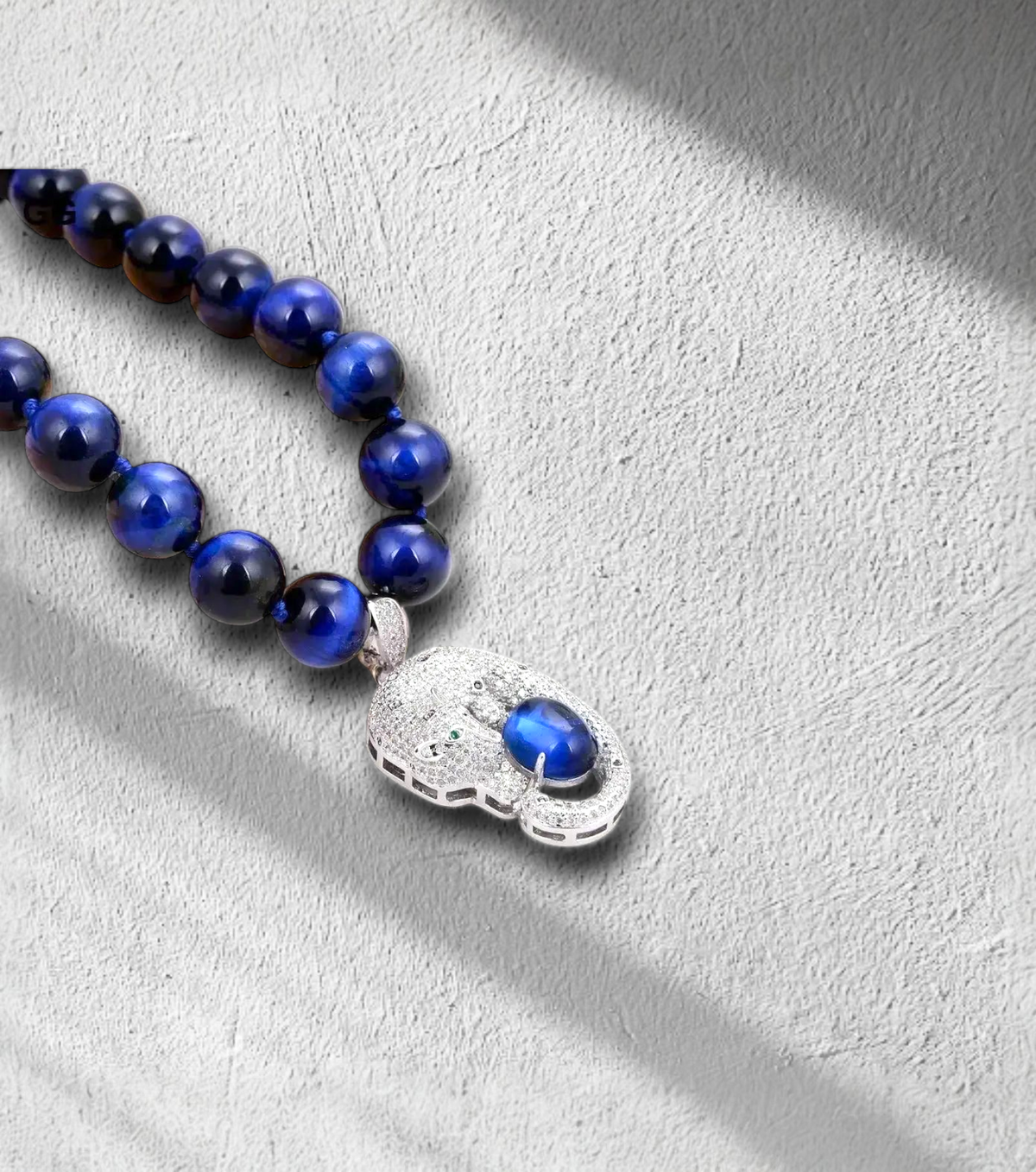 Semi-precious blue pearl necklace with Tiger Eye pendant, gold-plated clasp, bold statement jewelry for confident women. Zoharas Vogue