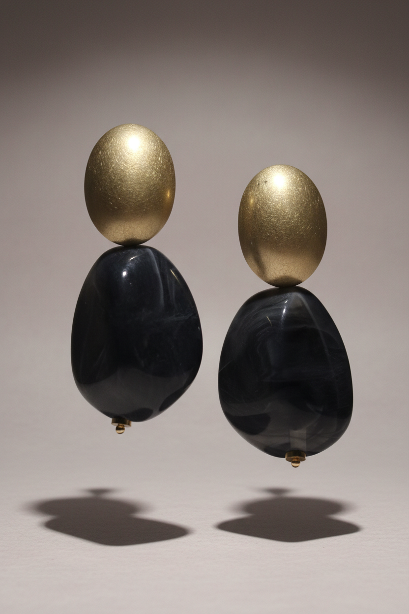 The Dior Statement Earrings, a chunky beaded necklace with alternating black and matte gold beads on a marble surface. ZoharasVogue