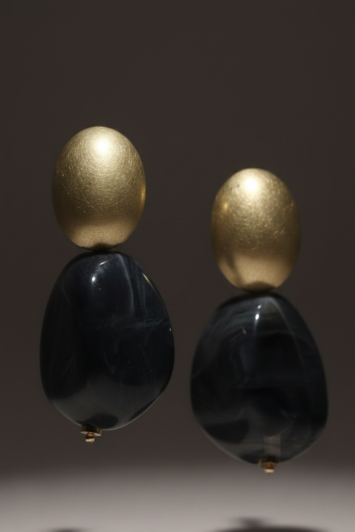 The Dior Statement Earrings, a chunky beaded necklace with alternating black and matte gold beads on a marble surface. ZoharasVogue