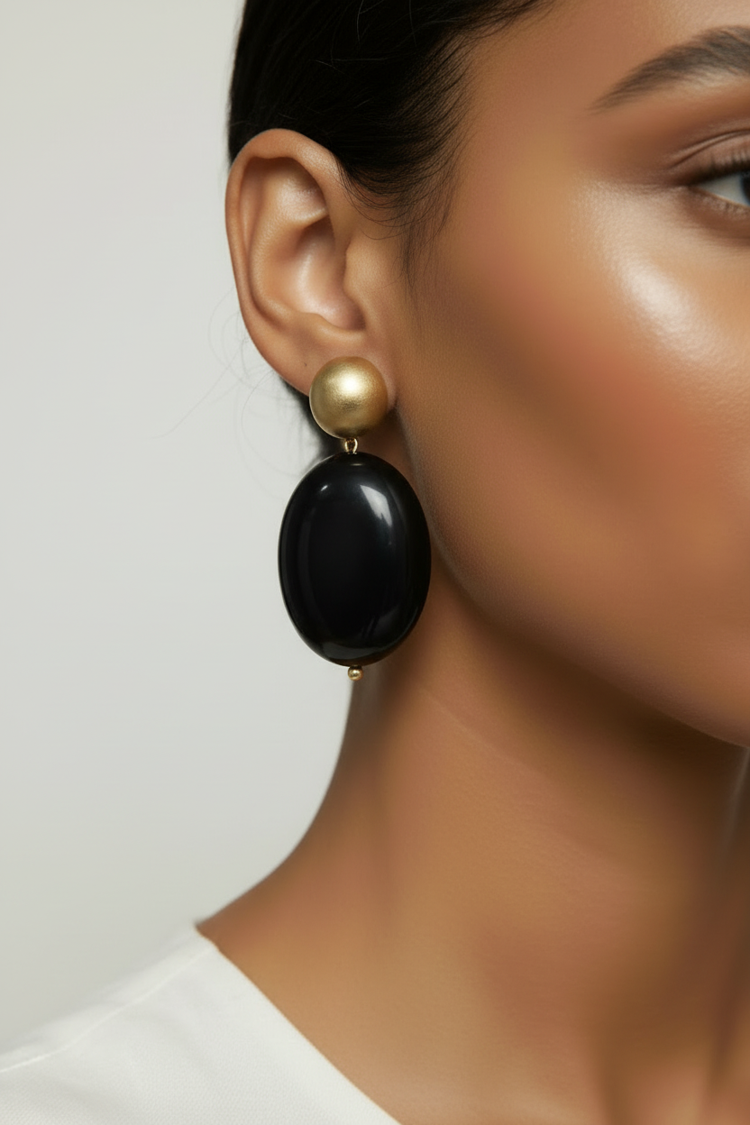 The Dior Statement Earrings, model wearing a chunky beaded necklace with alternating black and matte gold beads on a marble surface. ZoharasVogue