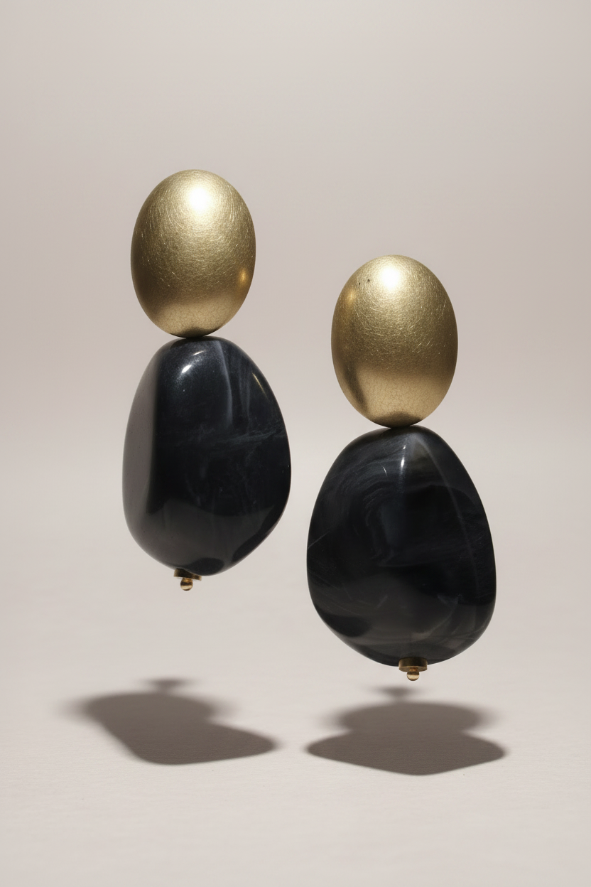 The Dior Statement Earrings, a chunky beaded necklace with alternating black and matte gold beads on a marble surface. ZoharasVogue
