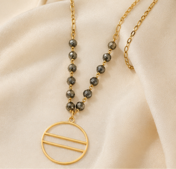 The Eclipse Necklace Handcrafted pyrite gemstone necklace and bracelet featuring faceted rondelle beads, gold chain links, and an open circle pendant in a modern luxury design.- ZOHARAS VOGUE