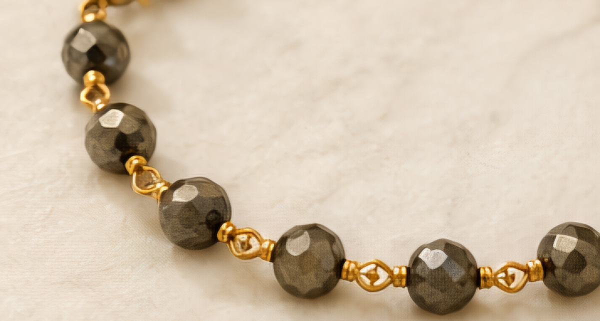 The Eclipse Necklace Handcrafted pyrite gemstone necklace and bracelet featuring faceted rondelle beads, gold chain links, and an open circle pendant in a modern luxury design.- ZOHARAS VOGUE