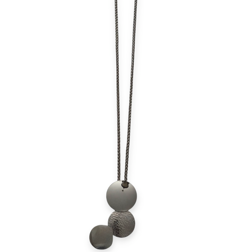 Long silver stainless steel necklace with three layered round pendants—polished, hammered, and matte—on a double chain, displayed on white background