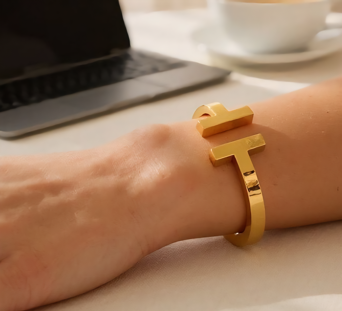 Vintage Script Bangle – 18k gold plated stainless steel cuff featuring a flower cross and customizable letter engraving. Rust-proof, adjustable, and durable with lasting shine. Perfect for everyday wear or as a gift, includes velvet pouch and care card.