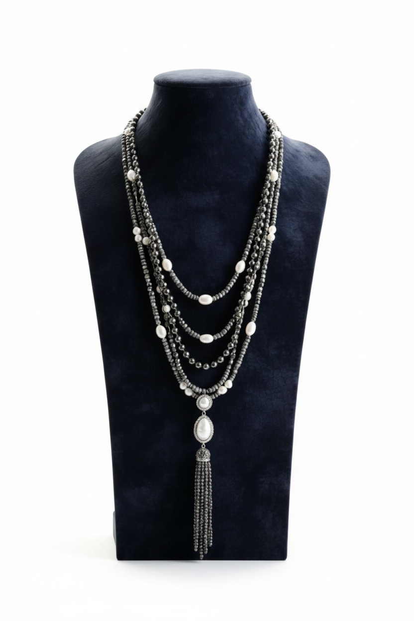 A studio product view of the Aurora Grace Wrap Bracelet featuring five layered strands of polished grey hematite beads and warm brass metal accents.