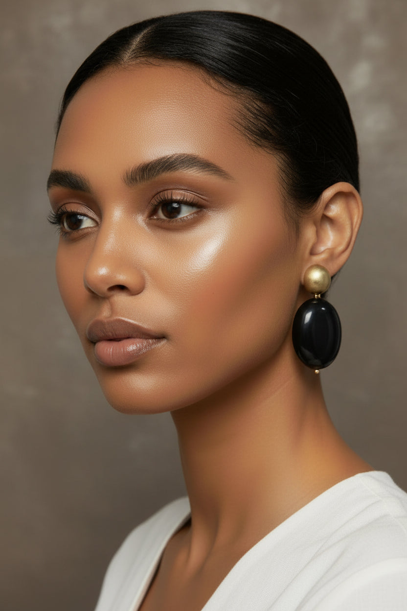 The Dior Statement Earrings, model wearing a chunky beaded necklace with alternating black and matte gold beads on a marble surface. ZoharasVogue