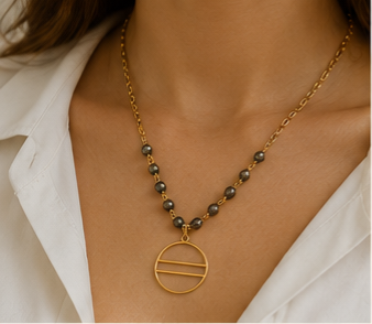 The Eclipse Necklace Handcrafted pyrite gemstone necklace and bracelet featuring faceted rondelle beads, gold chain links, and an open circle pendant in a modern luxury design.- ZOHARAS VOGUE