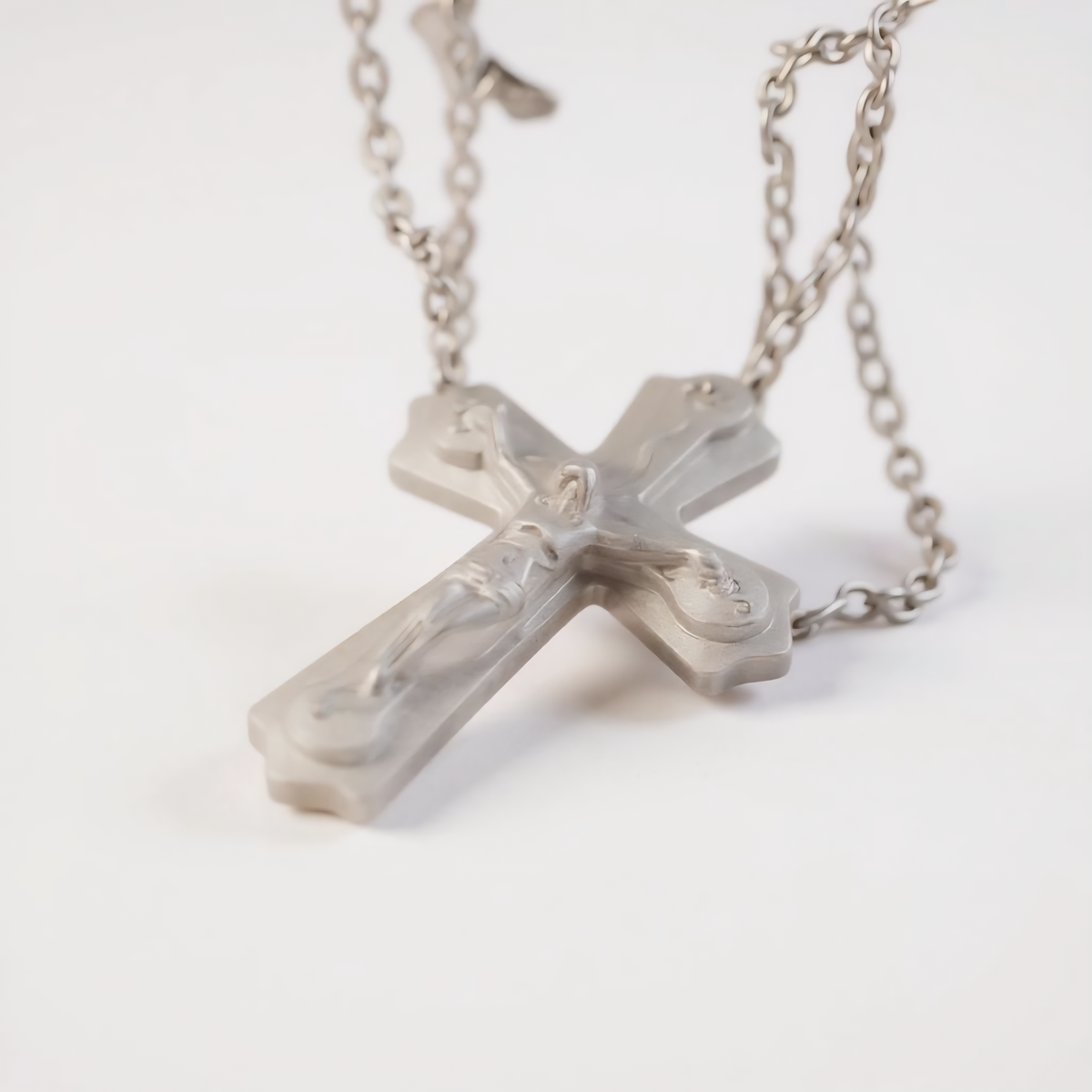 A durable stainless steel, this classic piece features a striking cross pendant, three-layered design adds depth and dimension, while the high-quality metal 