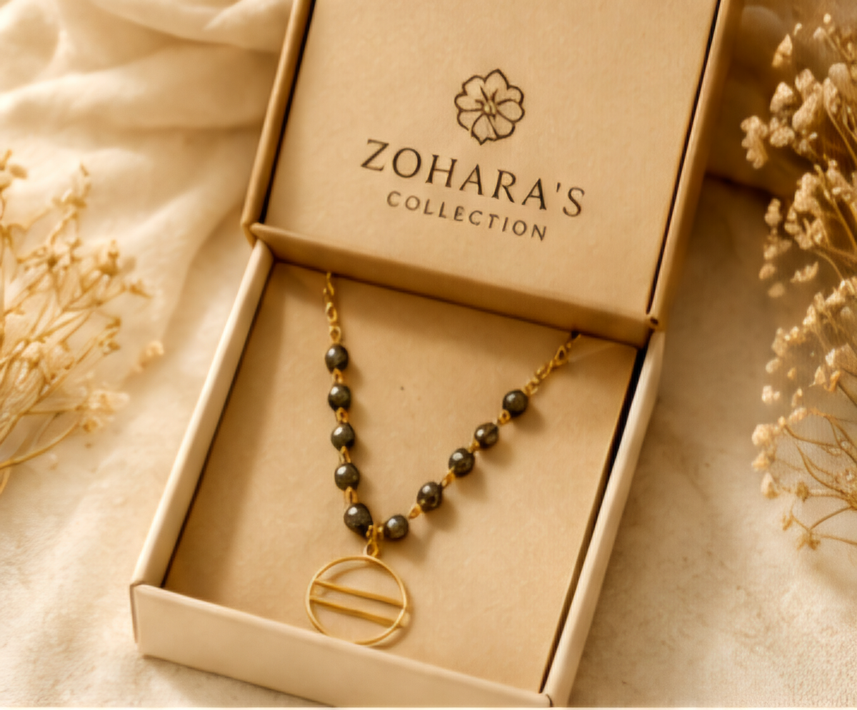 The Eclipse Necklace Handcrafted pyrite gemstone necklace and bracelet featuring faceted rondelle beads, gold chain links, and an open circle pendant in a modern luxury design.- ZOHARAS VOGUE